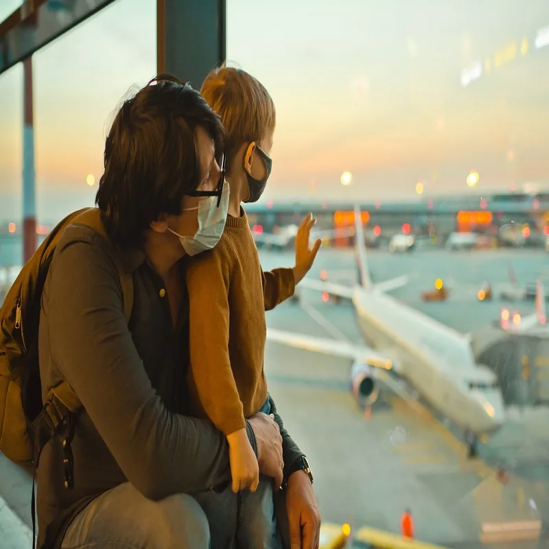 father and son looking at planes on the tarmac