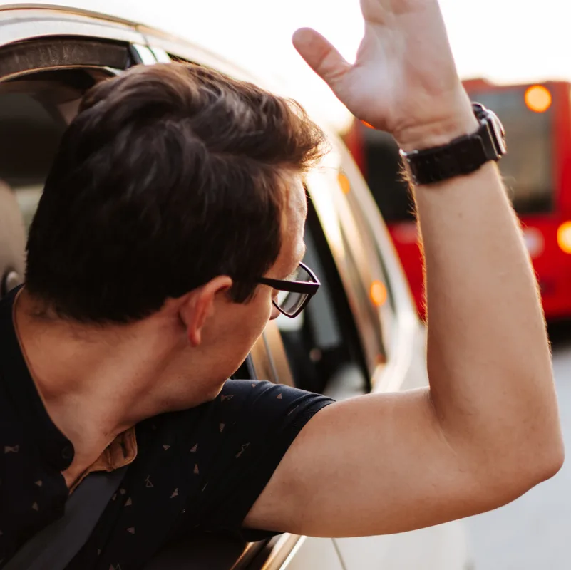 man waving out of car