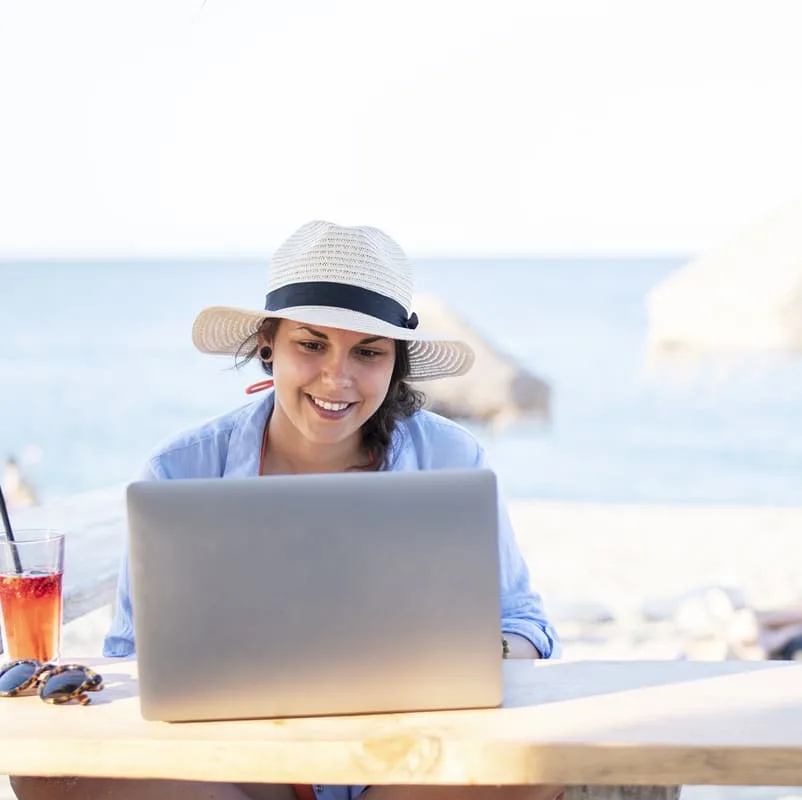 lady on computer on beach
