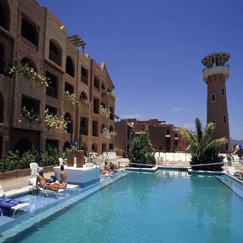 Tourists Relaxing by a Pool, Taking in the Sun at a Los Cabos Resort