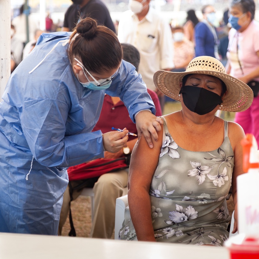 Lady receiving an injection from a health worker.