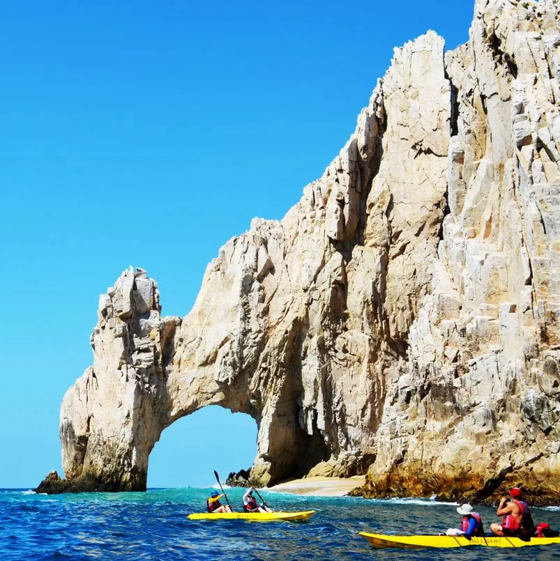 Tourists paddling on kayaks near the Los Cabos arch