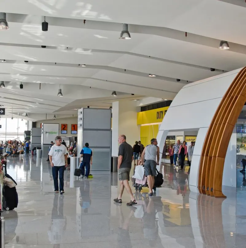 Los Cabos Airport Terminal with people walking around and a glimpse of the duty-free store in the background.