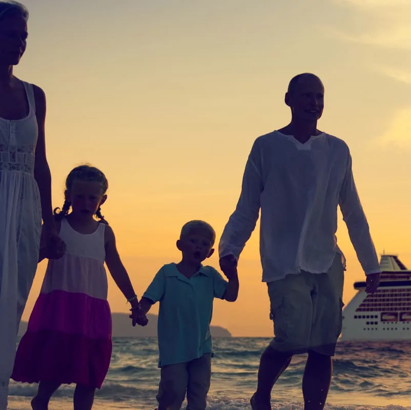 family walking on beach infront of ship