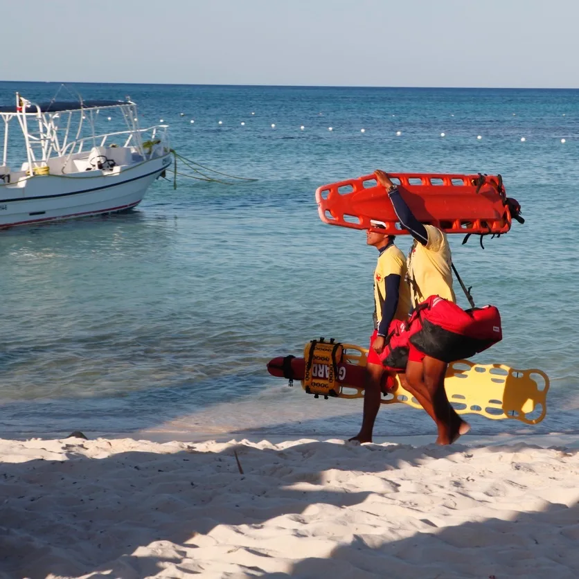 Two lifeguards carrying equipment