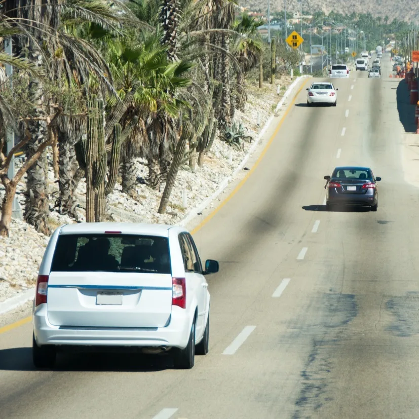 Highway 1 between Cabo San Lucas and San Jose Del Cabo. The vehicles are primarily those of residents with a few tourist rentals.