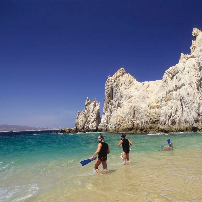 People snorkeling at a rocky beach