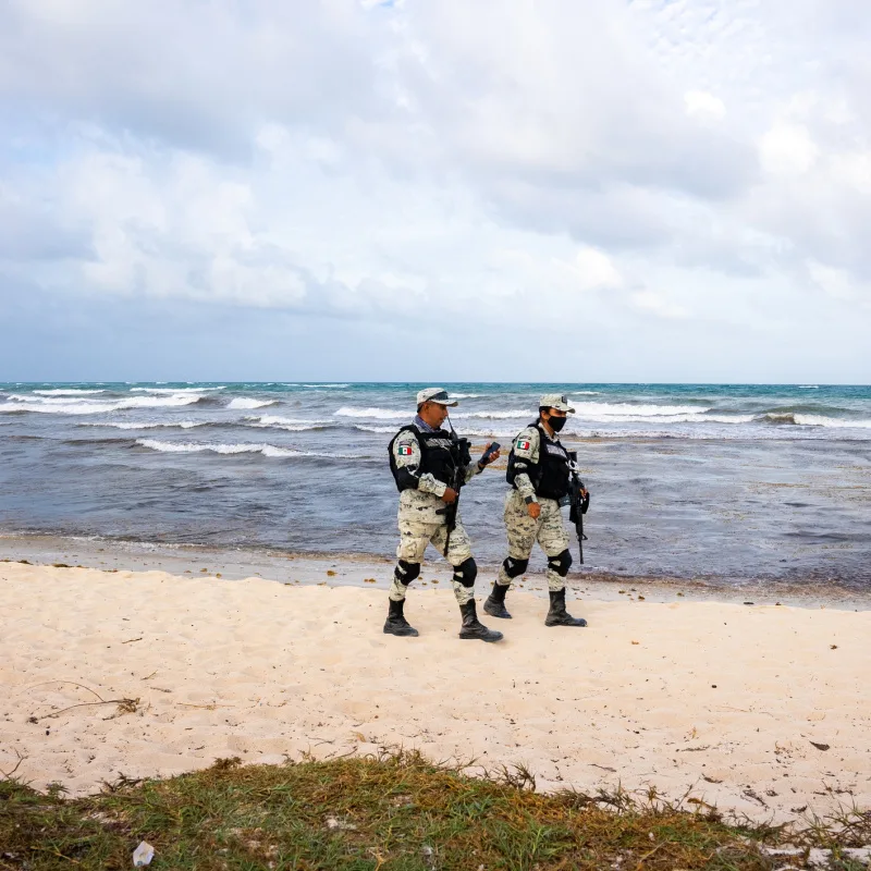 Two soldiers of Mexican army patrolling beach 