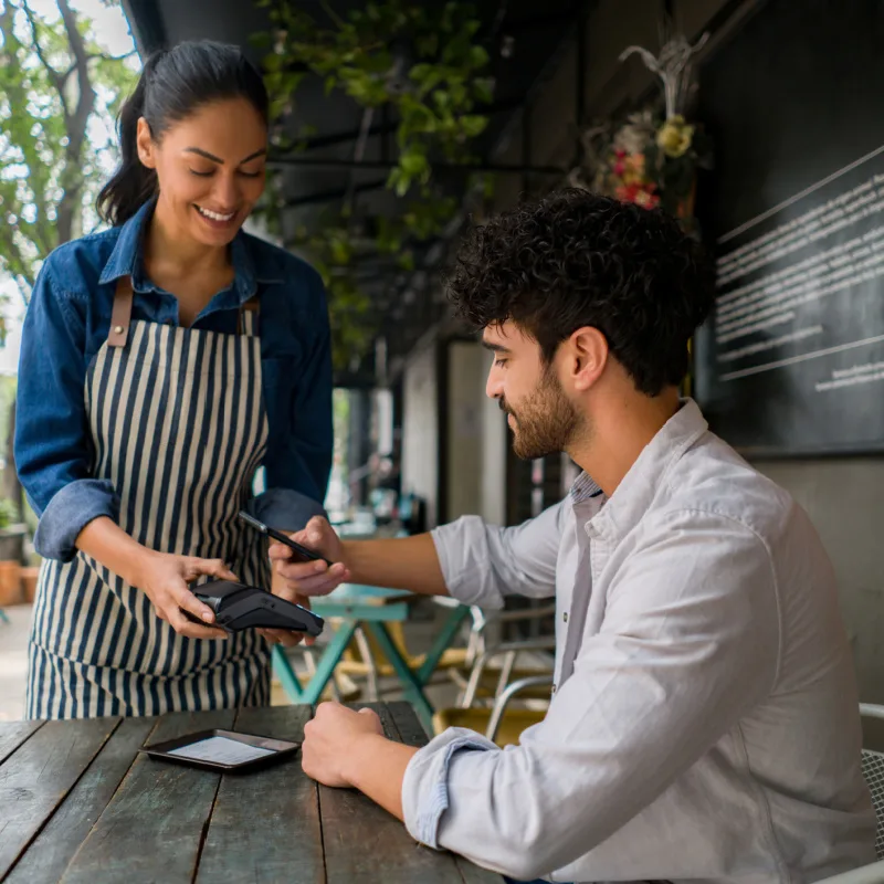 Man using cell phone to pay at restaurant