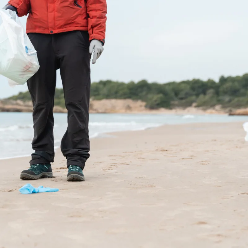 volunteer cleaning trash off beach