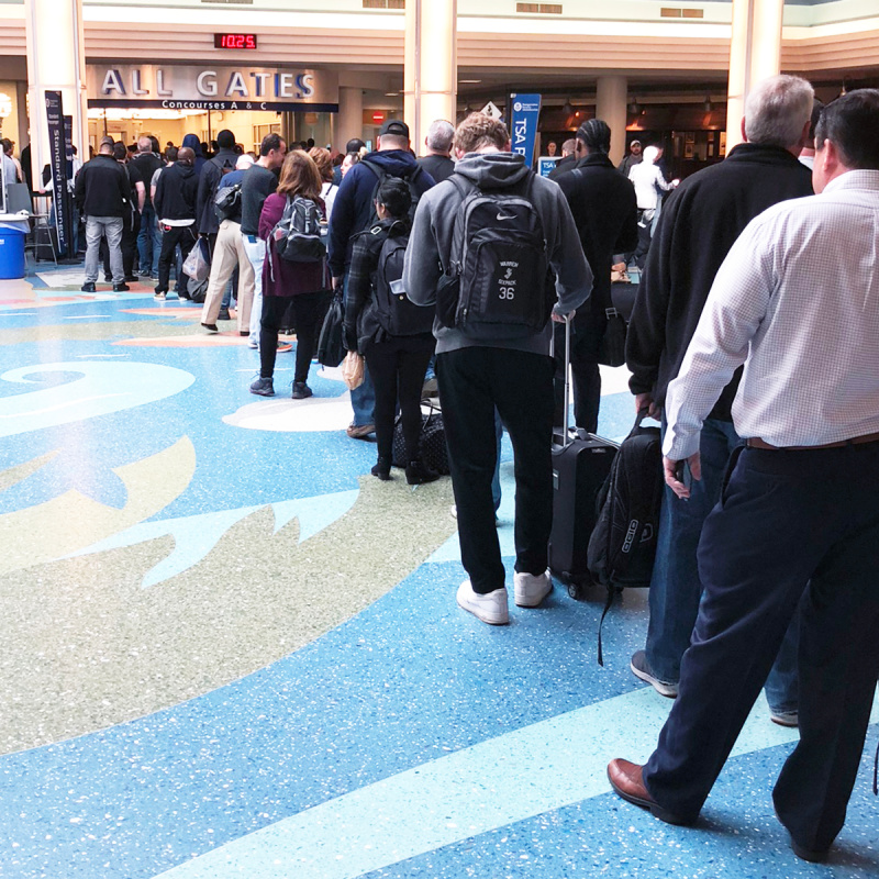 travelers waiting at security line at the airport