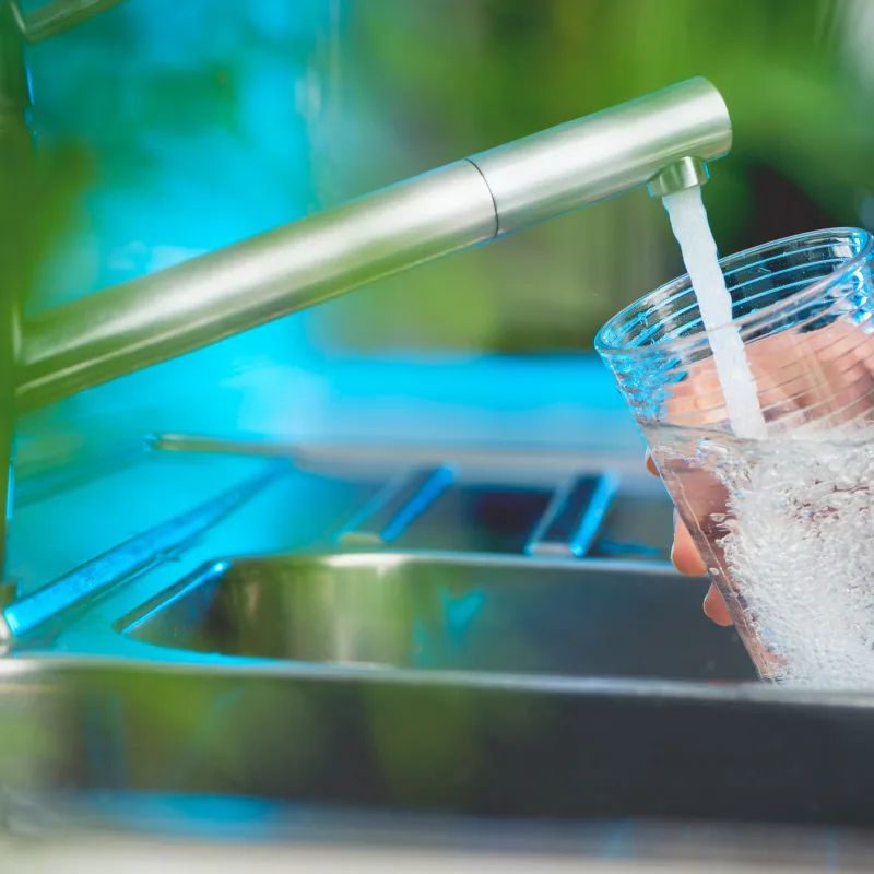 Water glass being filled at tap