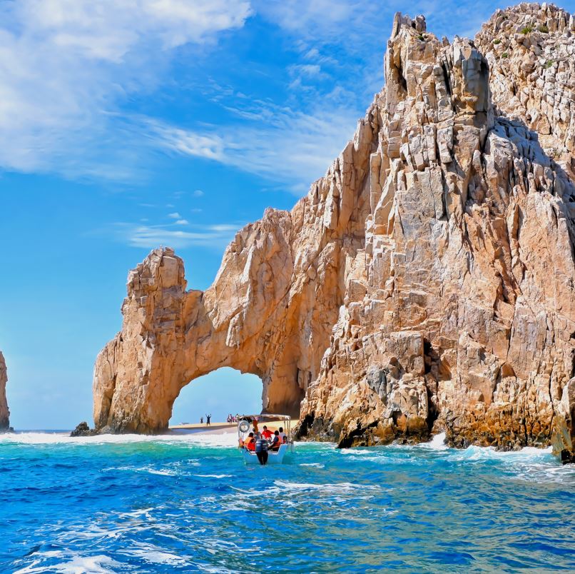 los cabos arch with boat of tourists in front of it