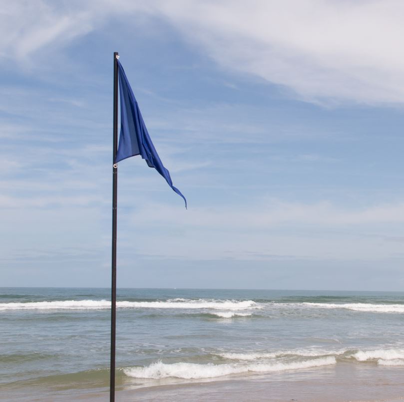 blue flag next to a beach