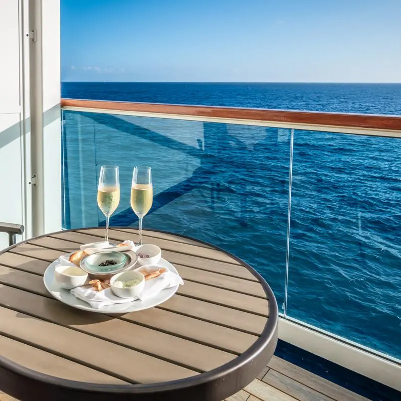 Pair of champagne glasses overlooking the ocean on deck of cruise ship