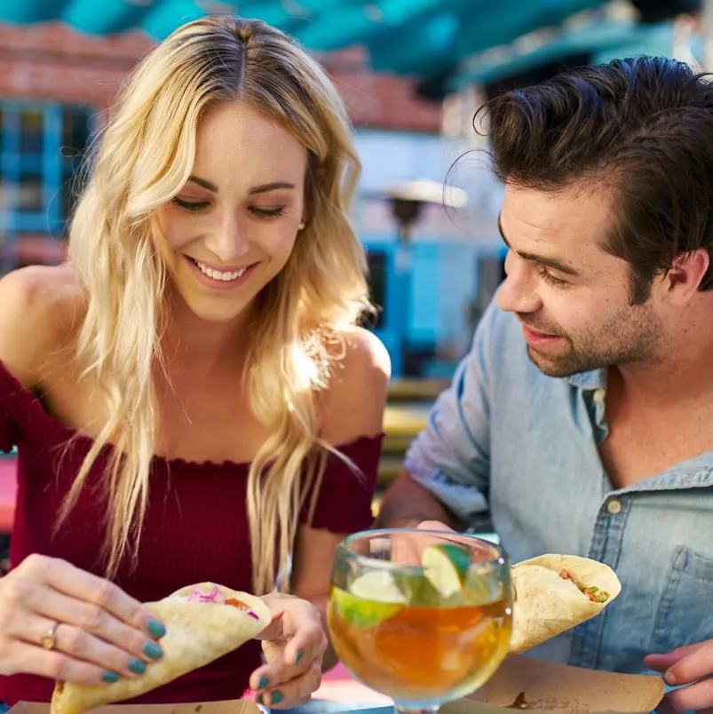 Two People Eating Tacos and Having a Drink