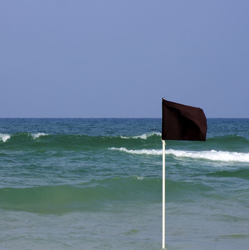 Black flag in ocean with waves