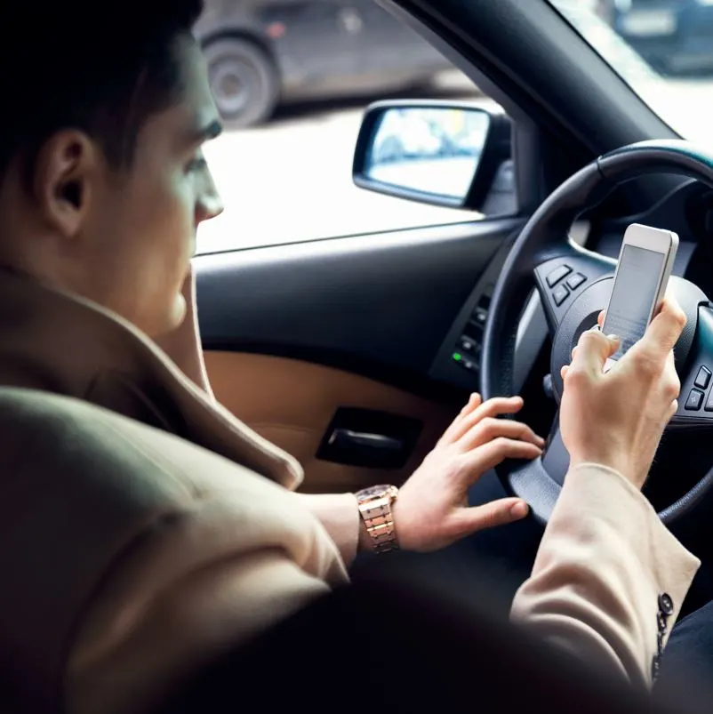 Man distracted with cell phone while driving