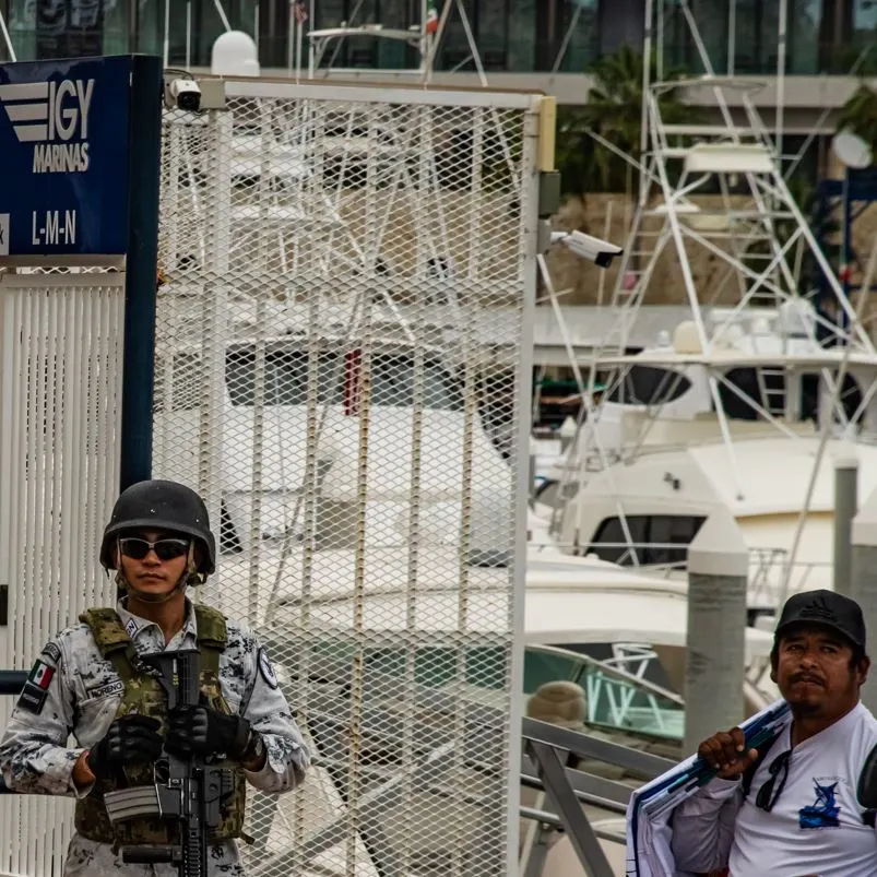 Mexico police officer near marina next to man selling clothes