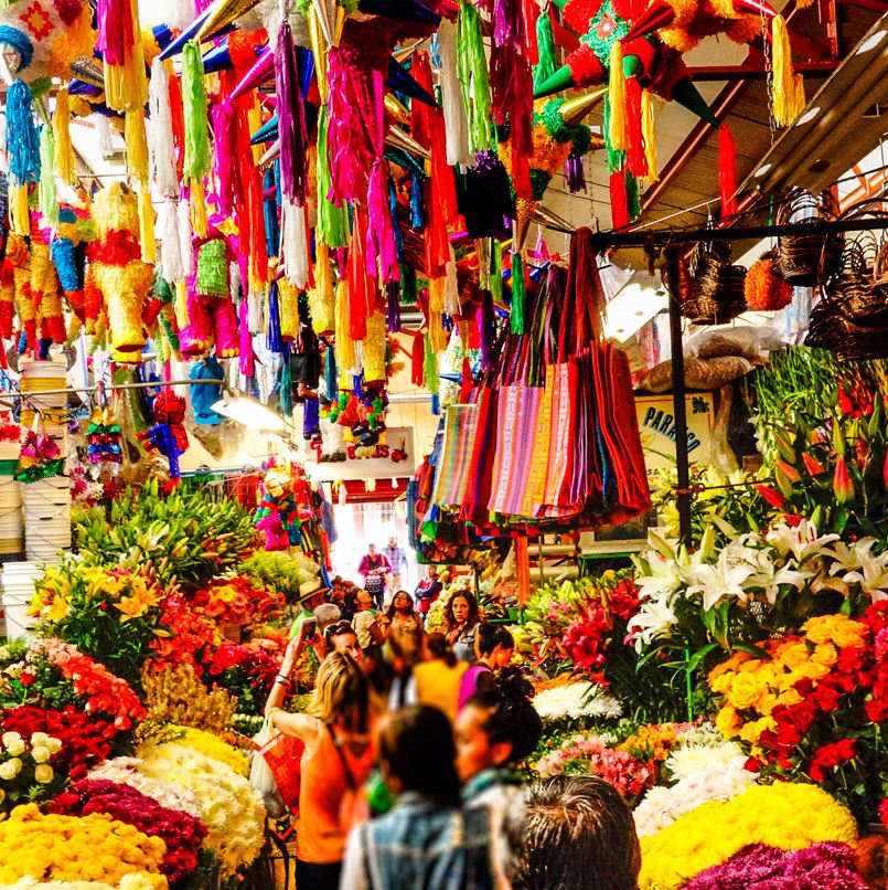 People in Mexican market with flowers