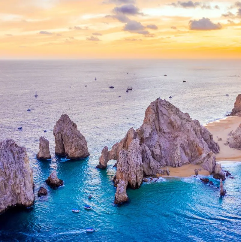 Boats sailing in the ocean at sunset