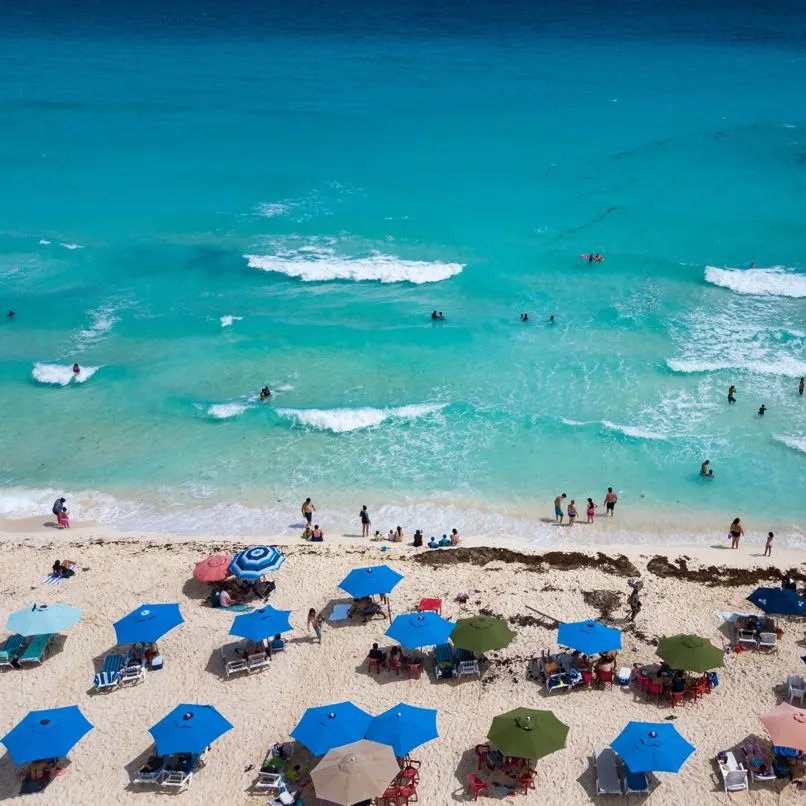 People on the beach with umbrellas in the sand