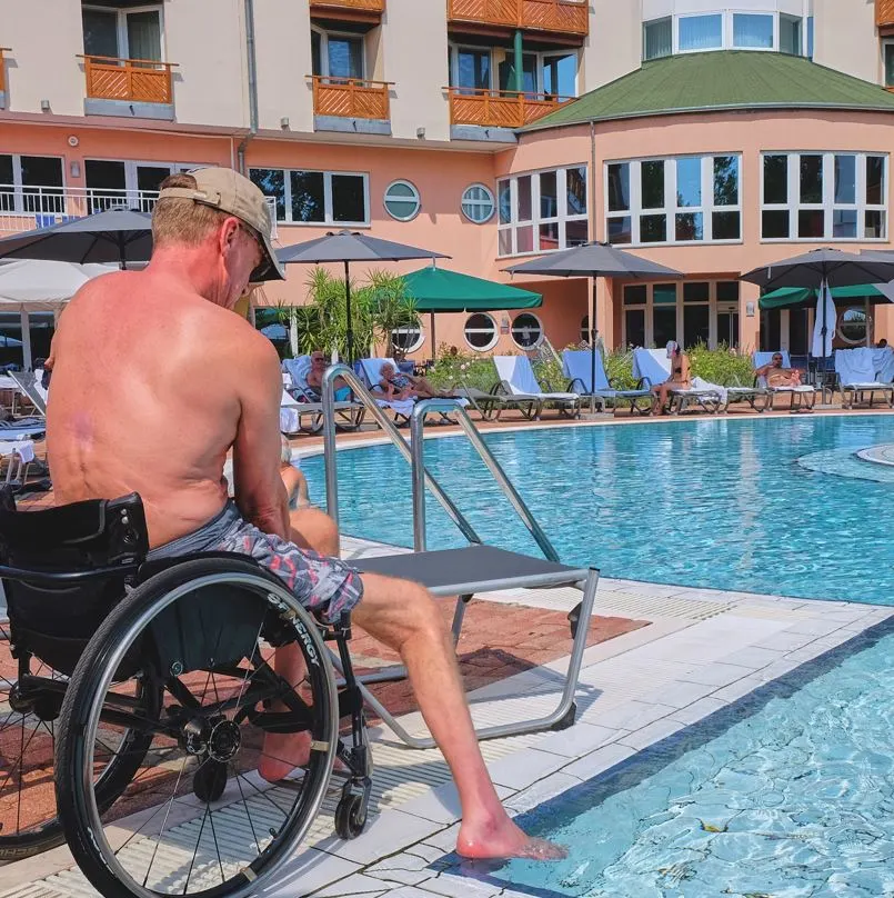 man in wheelchair next to a pool