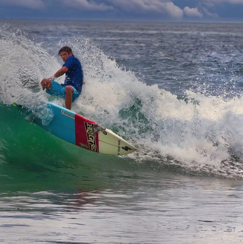 Surfer on surfboard in ocean with waves