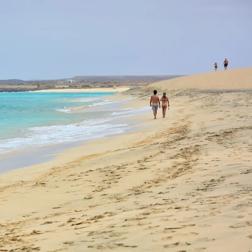 People walking on the beach in the sand