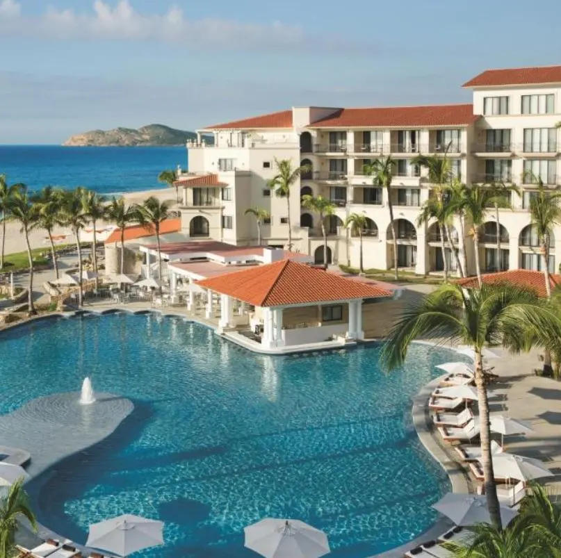 Resort near the beach with pool and palm trees