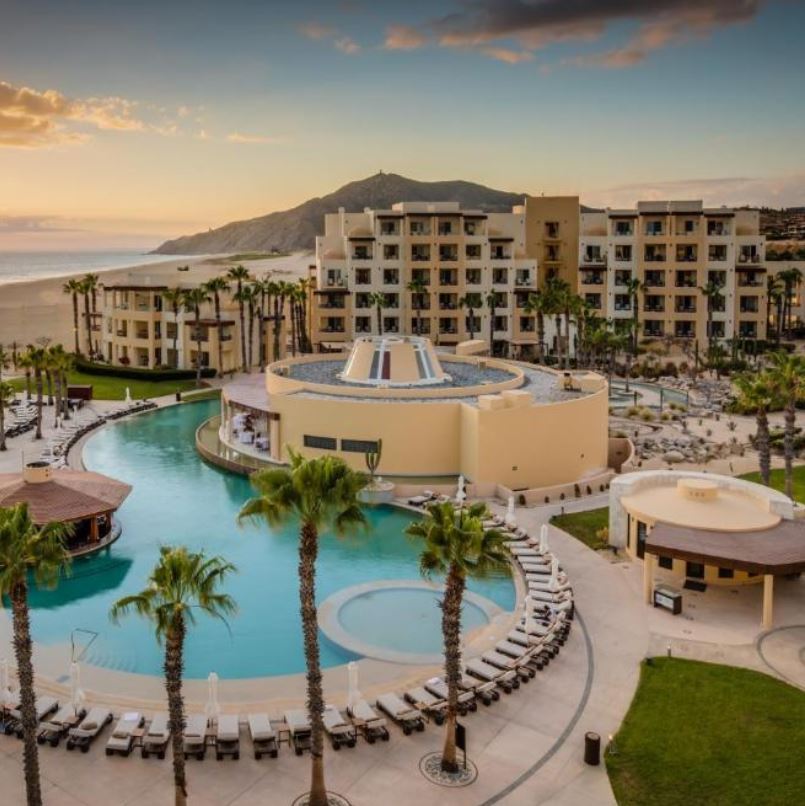 Beautiful resort pool at a luxury Los Cabos resort, surrounded by lush greenery.
