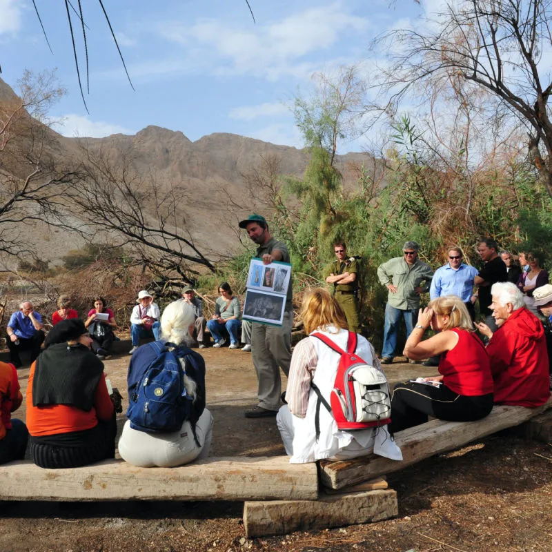 Tour guide showing maps to a group of tourists