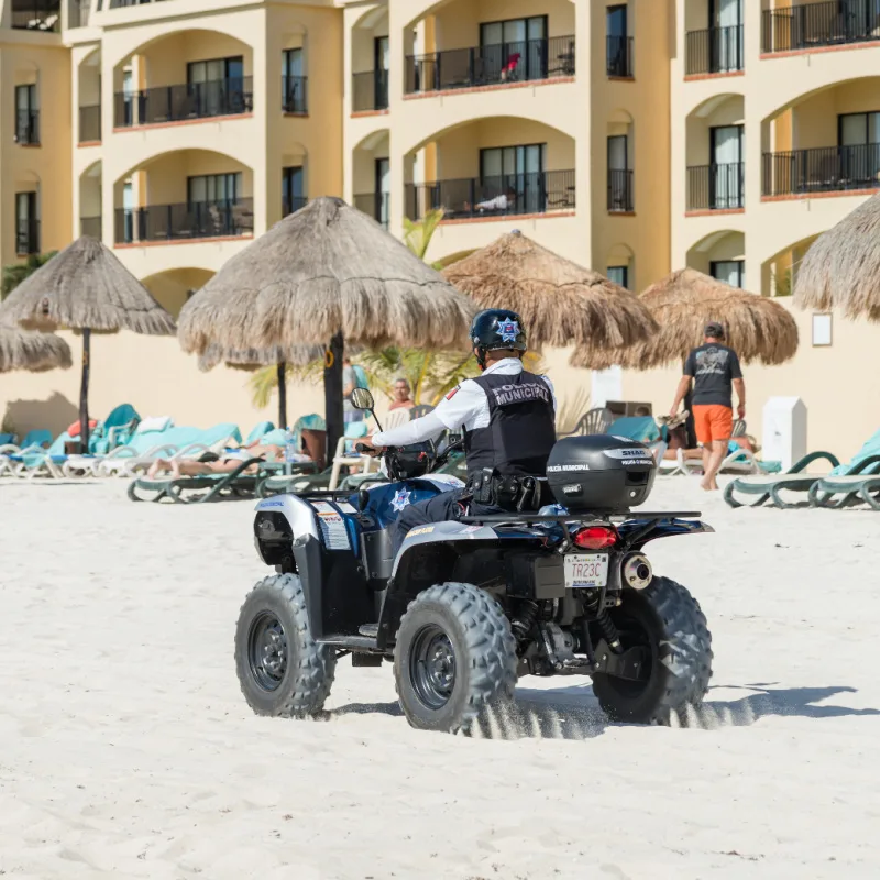 mexico police officer riding atv on beach