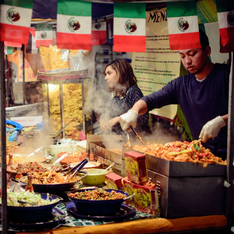 man cooking some food in los cabos at street stand