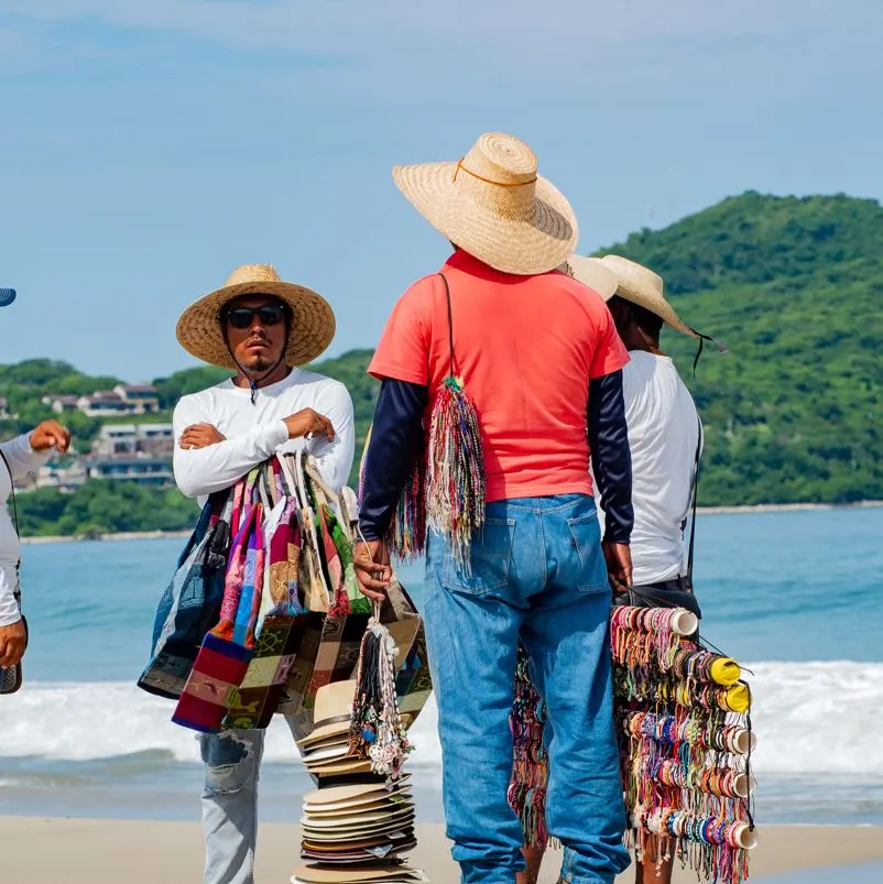 Vendors talking on a beach in Mexico.
