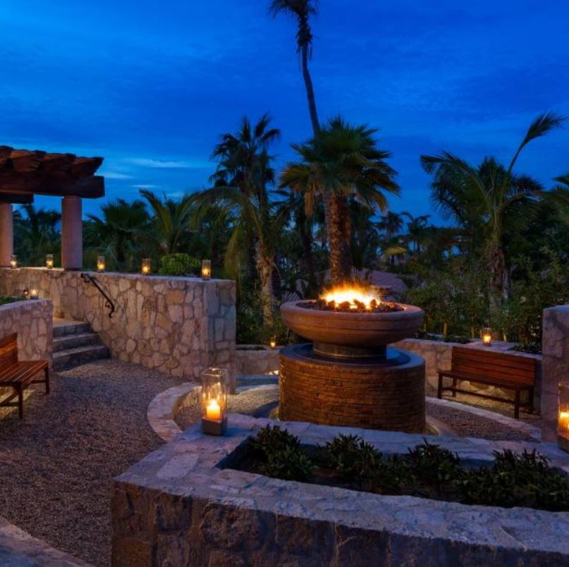 Outdoor terrance with fire and candles near the ocean