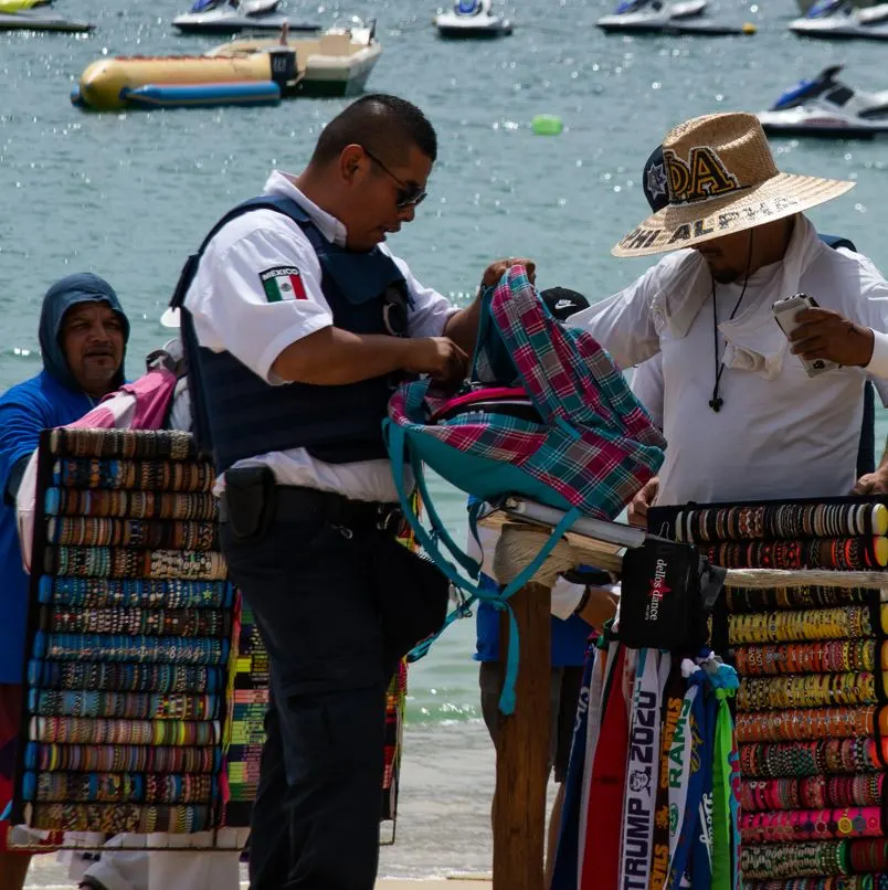 Police searching a backpack on the beach