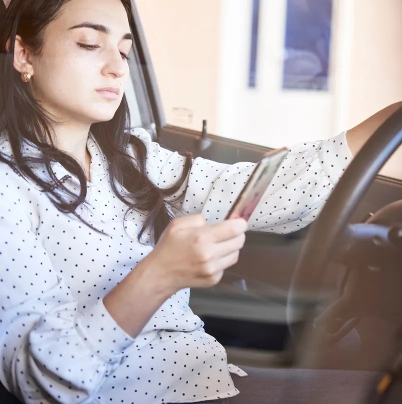 Woman using her cell phone while driving