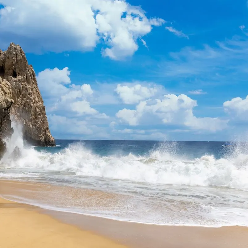 Waves crashing into shore near rocks in ocean