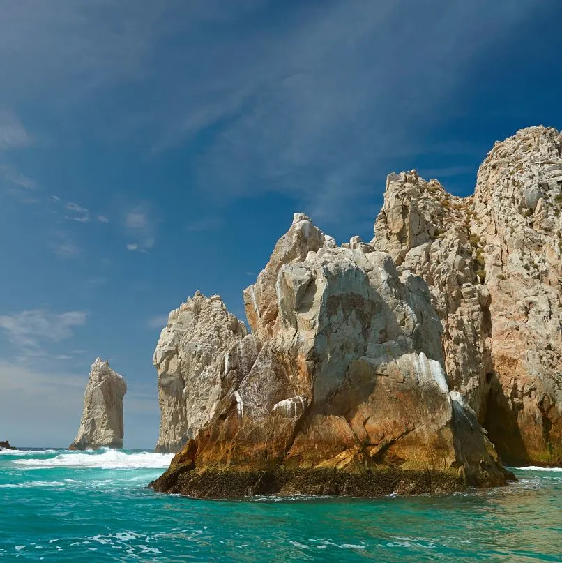 Rocks in the ocean with darker skies and waves