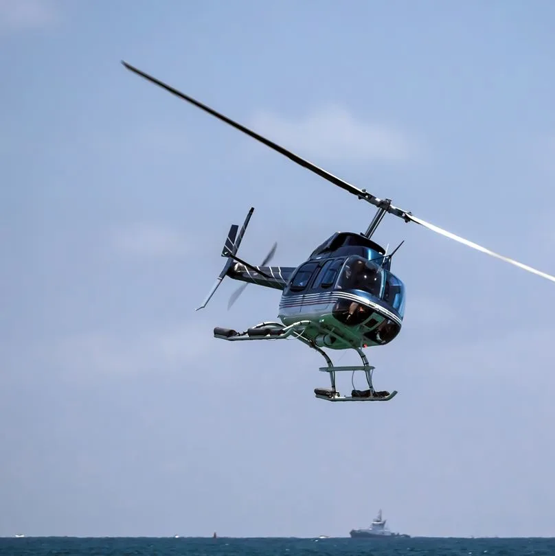 Helicopter flying over the ocean