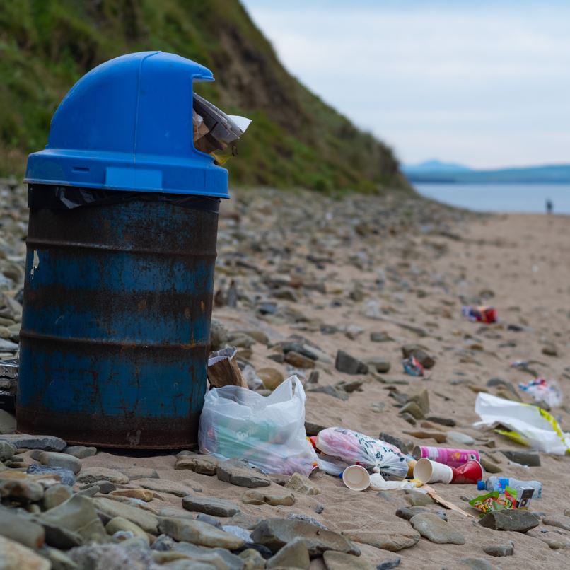 filled up trash can at the beach