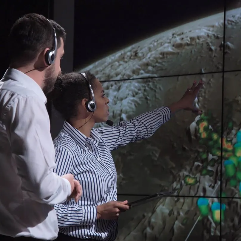 Meteorologists looking at map and storms with headsets