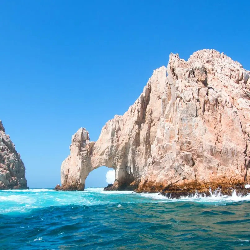 Rock structure from the ocean with waves and blue water