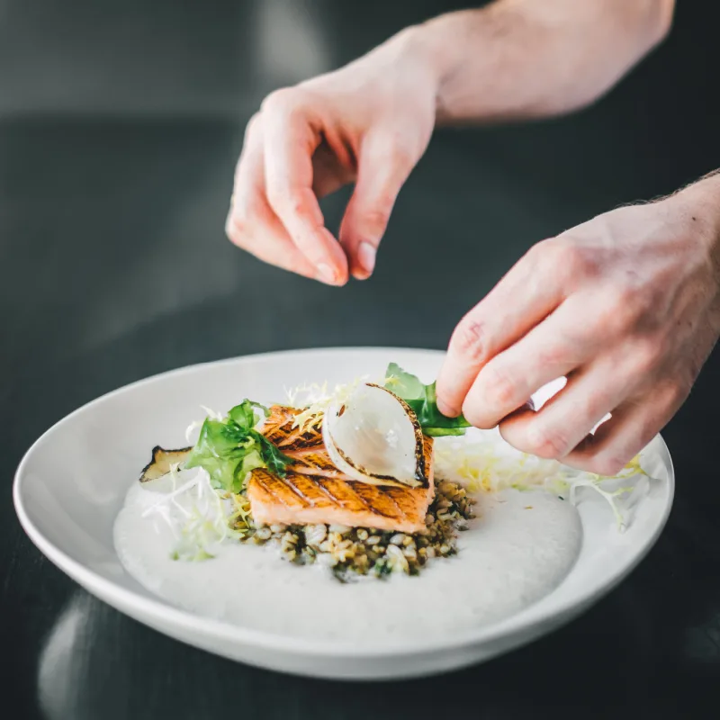 Chef adding final touches to a culinary experience.