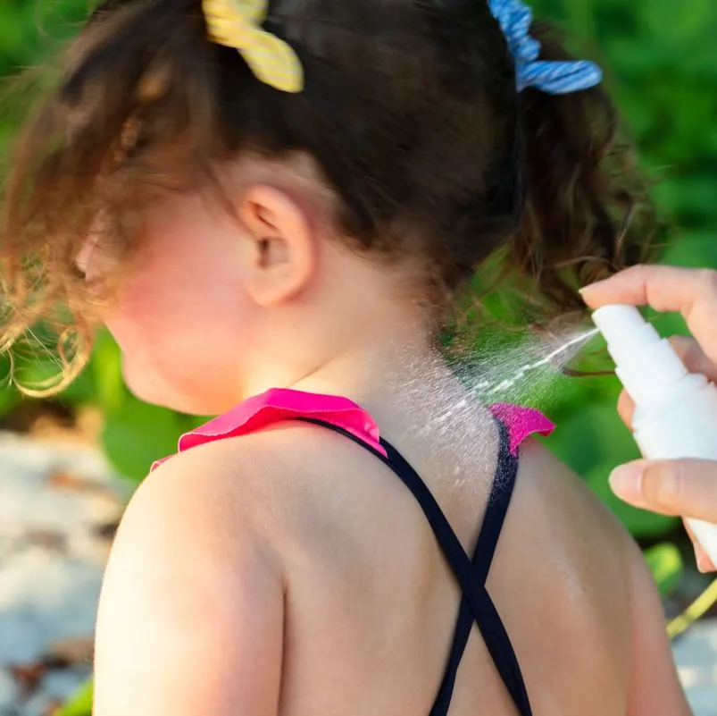 Applying Insect Repellant To Little Girl