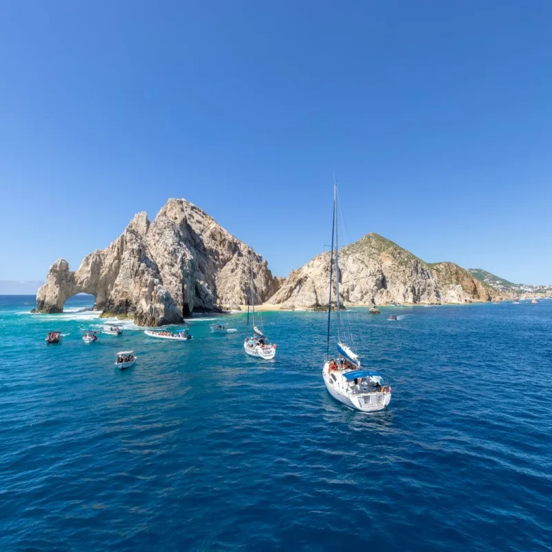 Sailing in Cabo with Land's End in the background.