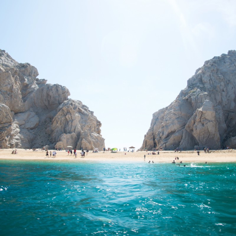 Sunny Cabo on a beautiful day with people enjoying the beaches near the famous Arch of Cabo San Lucas.