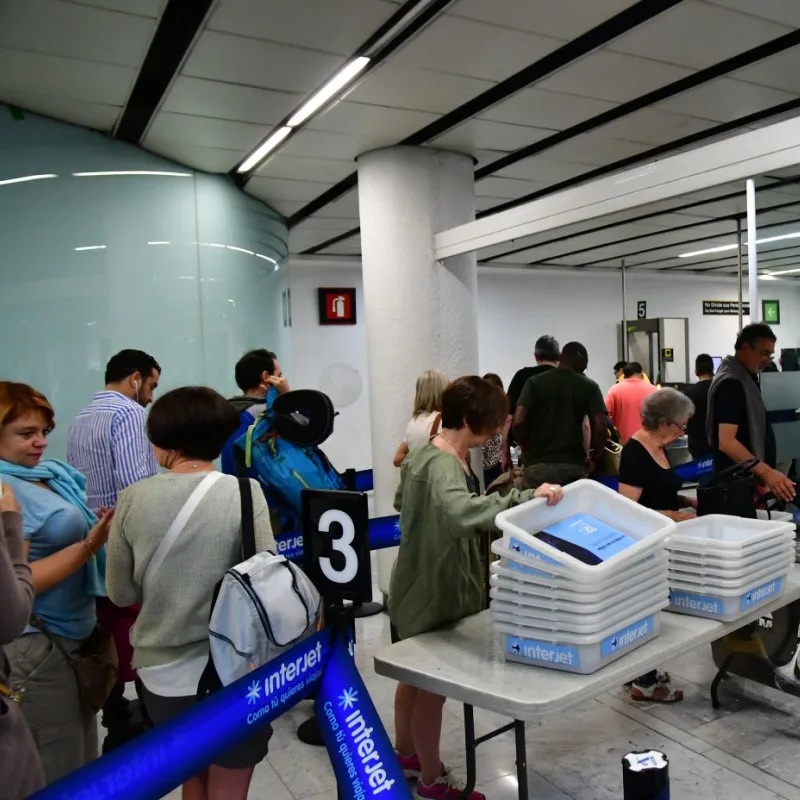 Airport Security in Mexico with people walking through and having their belongings checked.