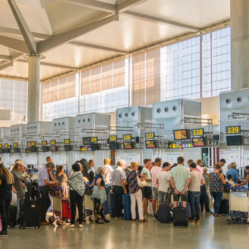 long line of people waiting to check in at the airport. 